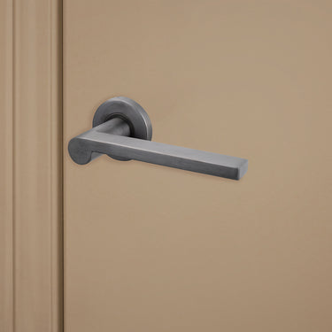 Caserta deurklink Gun Metal PVD gecoat op rond rozet van Lavuzo op beige deur, rechteraanzicht