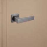 Strakke Gun Metal Imperio binnendeurklink van Lavuzo op beige achtergrond, linkeraanzicht