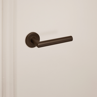 Linkerprofiel van de Mantua klink in brons op een beige ondergrond, detail van de afwerking.