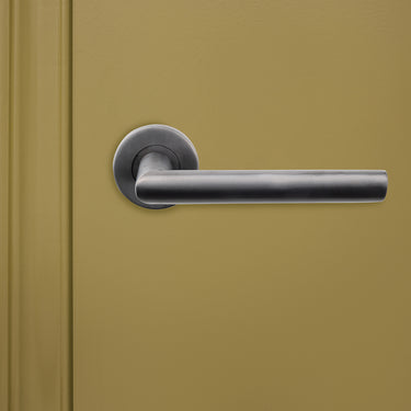 Lavuzo Ragusa deurklink Gunmetal PVD met rond rozet op groene binnendeur, vooraanzicht